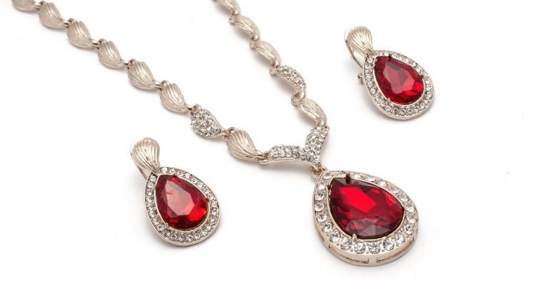 gold necklace and earrings with rubies isolated on white